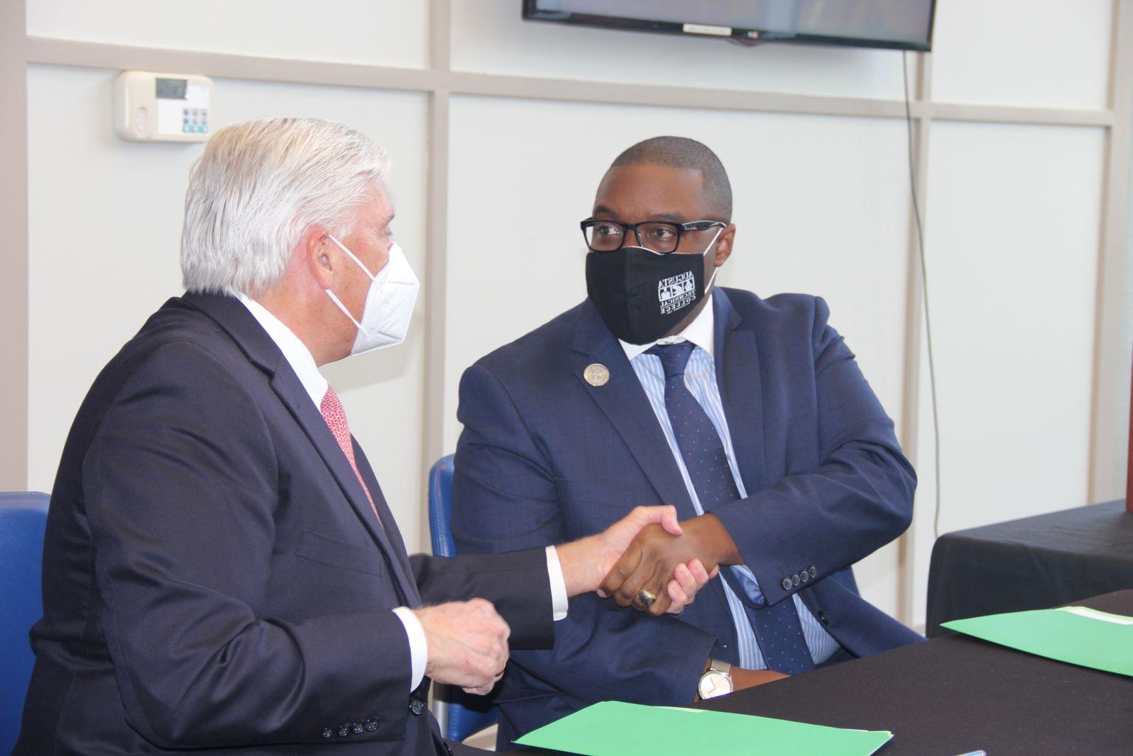 President of Augusta Technical College, Dr. Jermaine Whirl, shakes hands with University Health Care System Chief Executive Officer, James R. Davis.